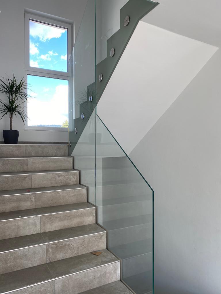 Glasgeländer an heller Innentreppe in Wien – SOS Glaserei